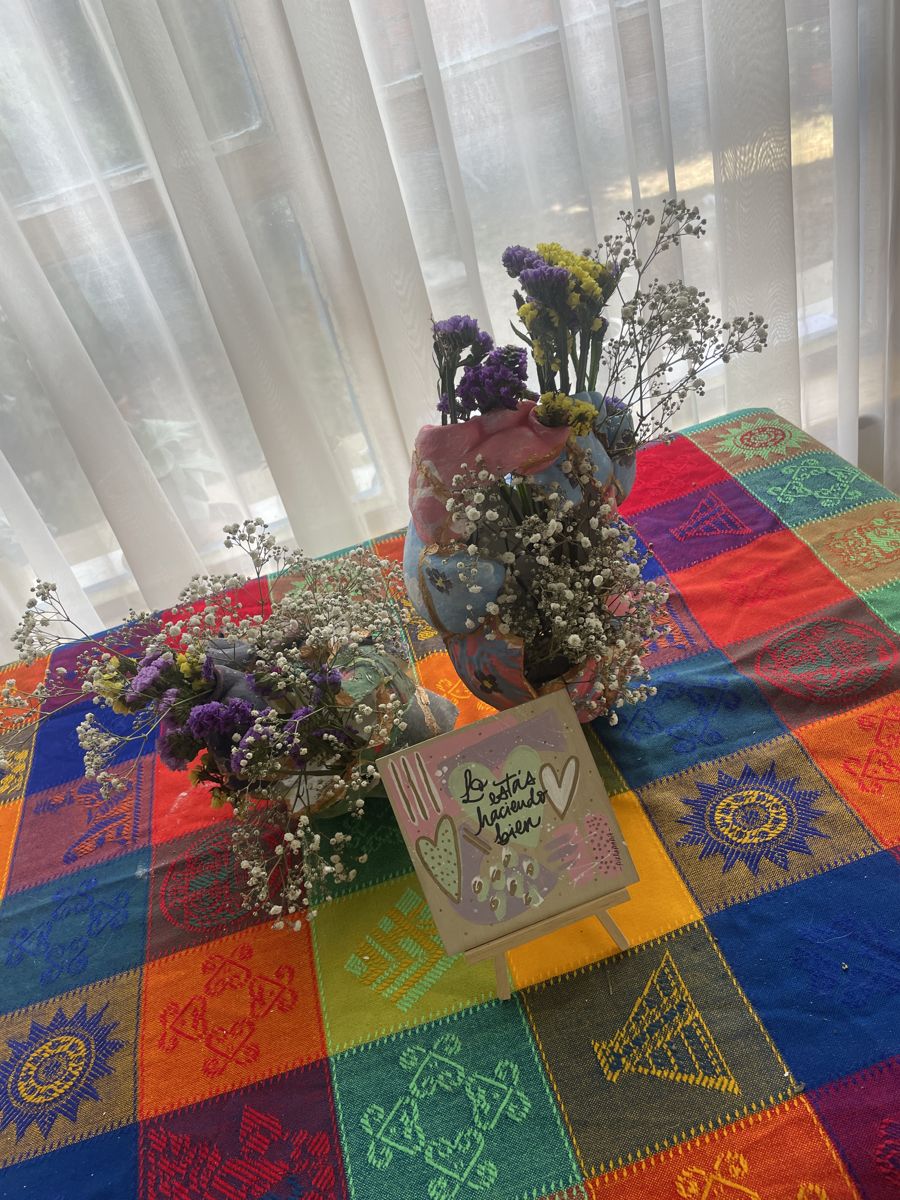 Mesa del taller con flores secas y macetas Kintsugi