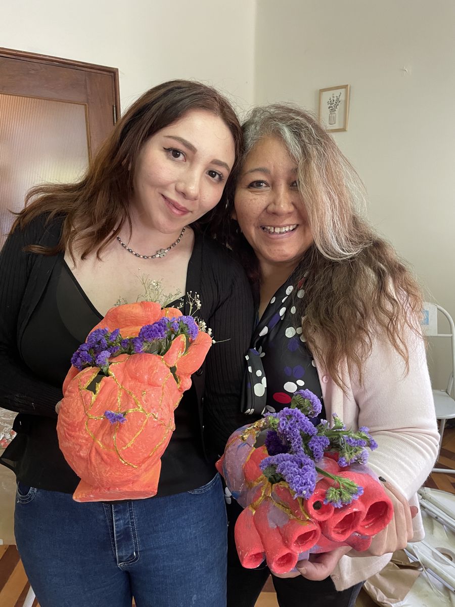 Dos participantes con sus macetas y flores